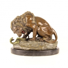 A bronze statue/sculpture of a lion and a snake