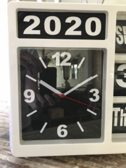 A clock with year, date and time, with stand, but can also hang on the wall, white