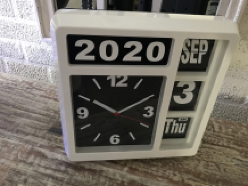A clock with year, date and time, with stand, but can also hang on the wall, white